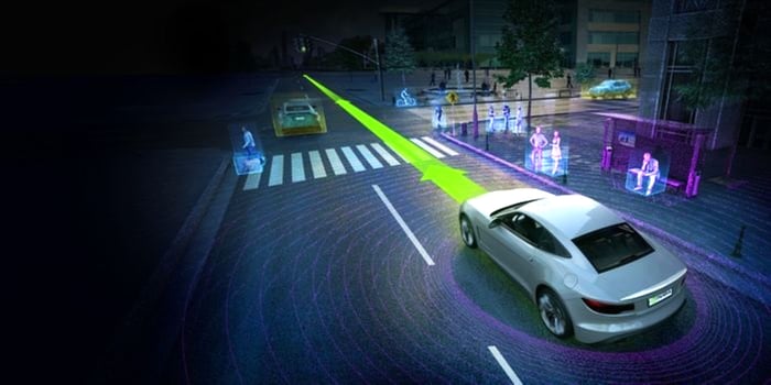 A driverless car on a city road with pedestrians on sidewalk.