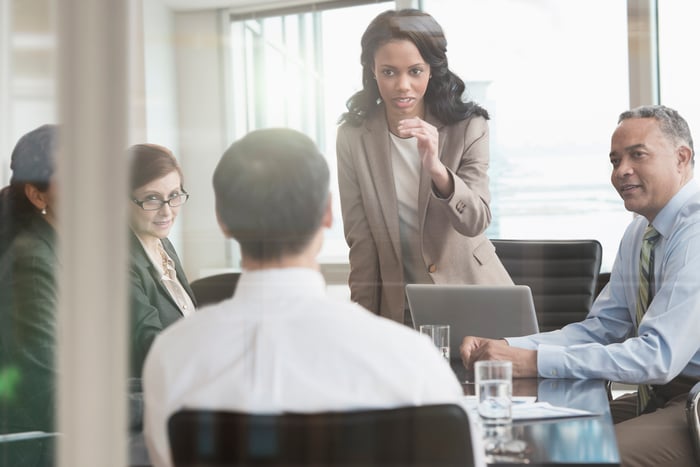 A business person is having a discussion with colleagues during a professional meeting.