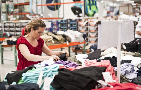 Woman shopping for clothes at warehouse store.