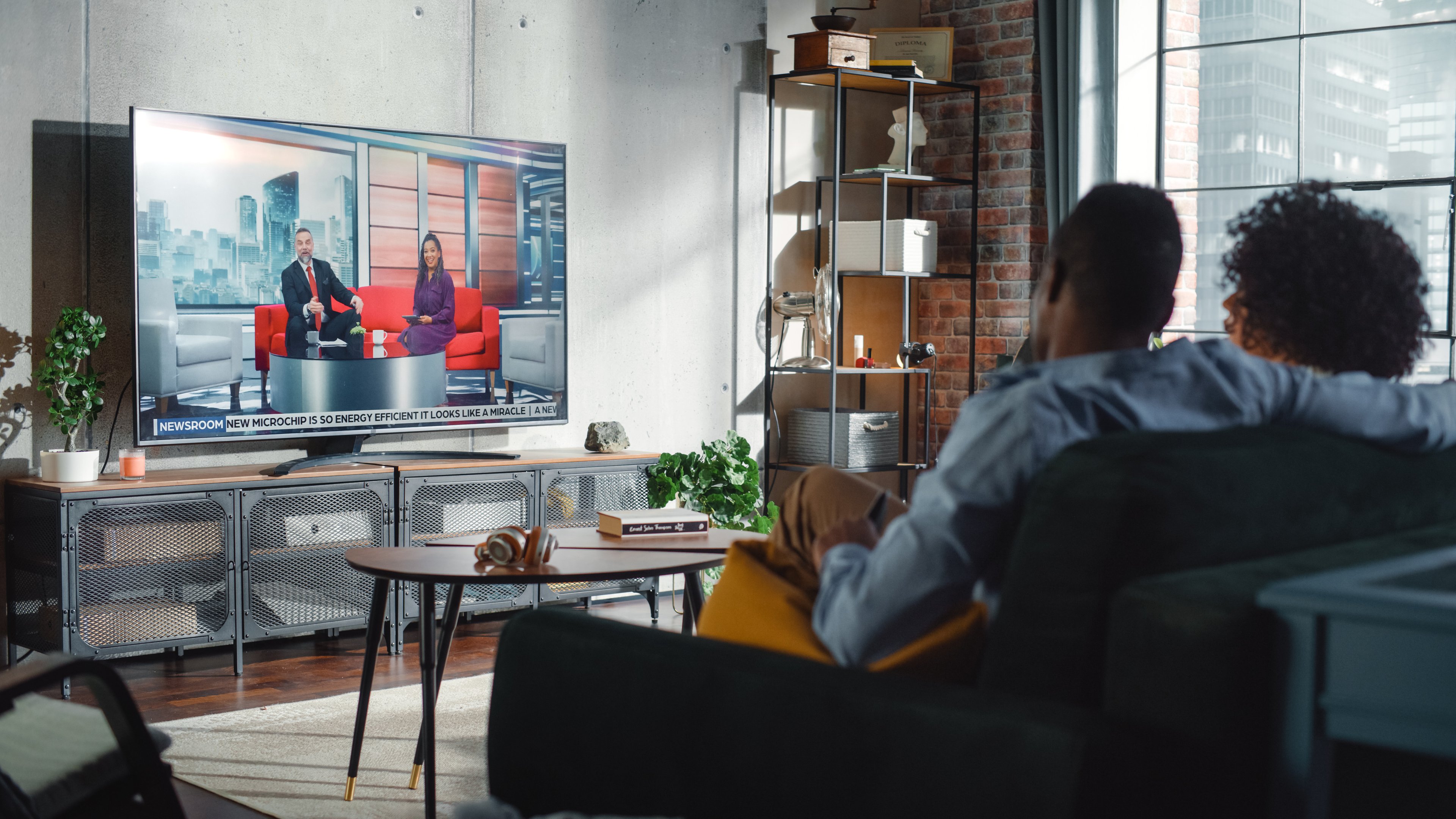 Couple watching TV in their living room.