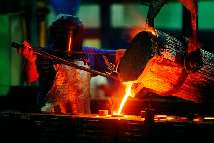 Steelworker pouring molten steel.