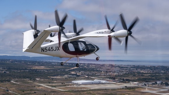 Joby's eVTOL in flight over flat, sparsely populated terrain. 