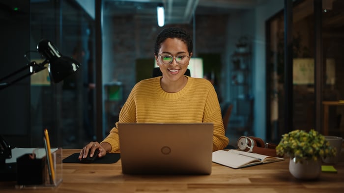 An investor works on a laptop in a darkened office.