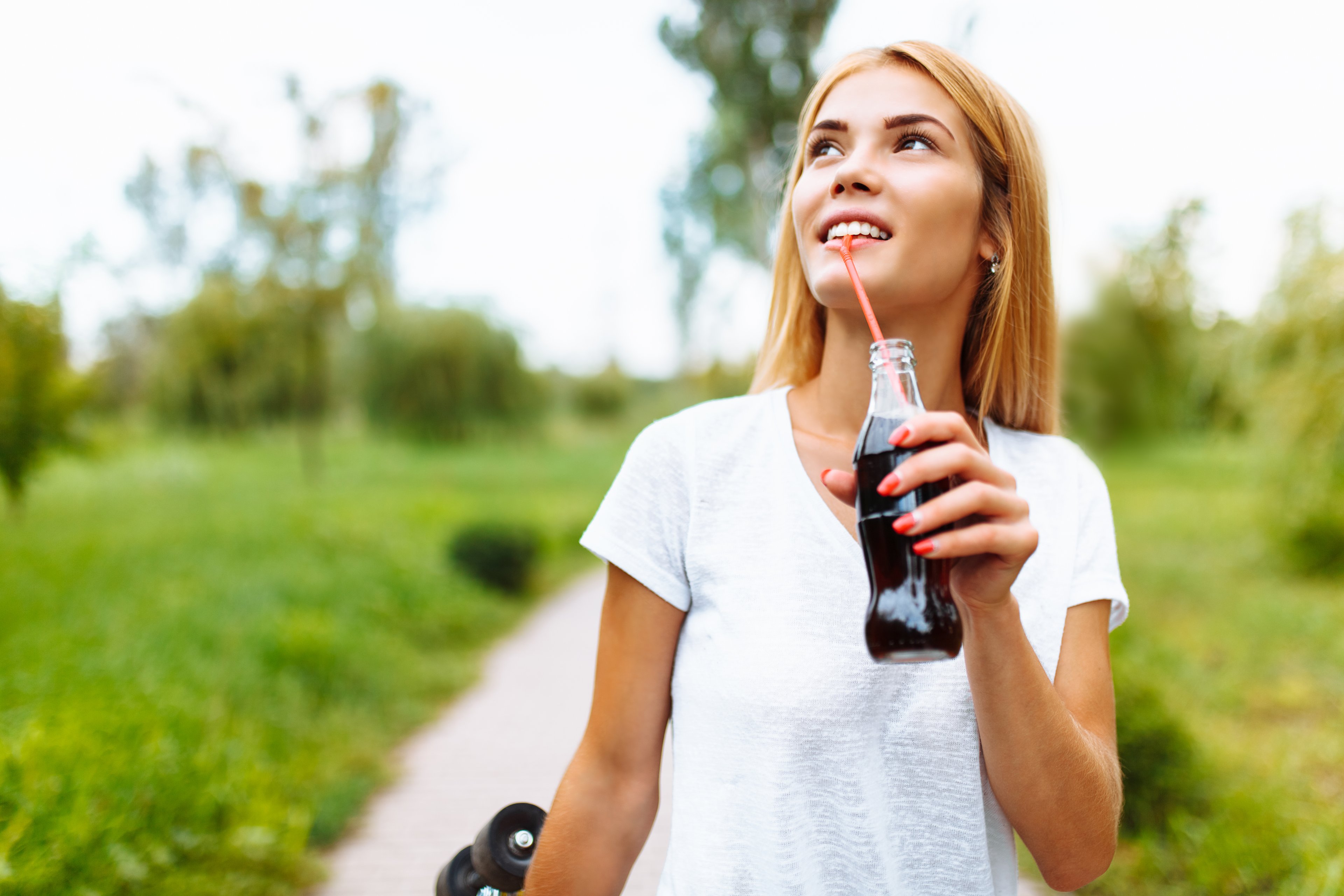 Person drinking from a bottle with a straw.