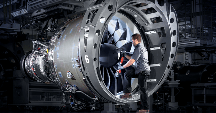 A technician works inside of an aircraft engine.