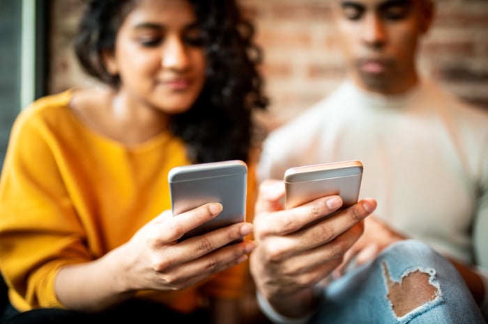 Two people using mobile phones.