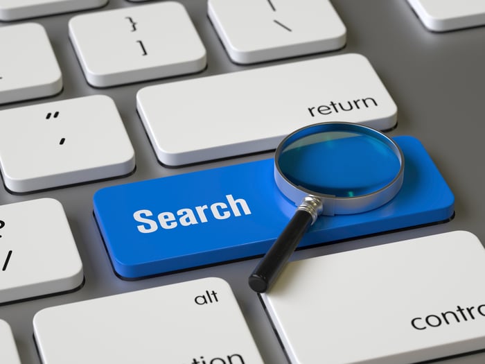 Keyboard with a magnifying glass and blue button that says Search on it. 