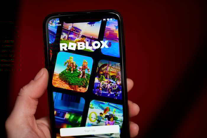 The Roblox platform is displayed on a smartphone.