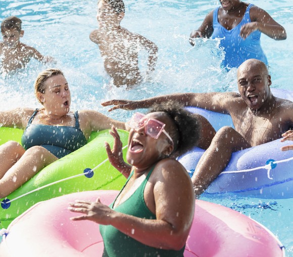 People laughing and having fun in a swimming pool.