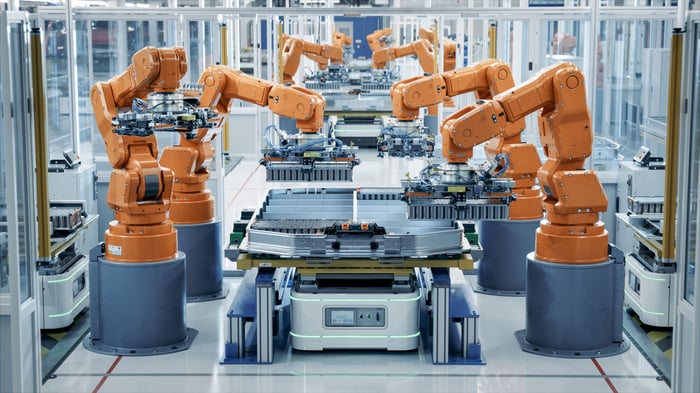 Robotic arms assembling lithium-ion battery packs for electric vehicles.