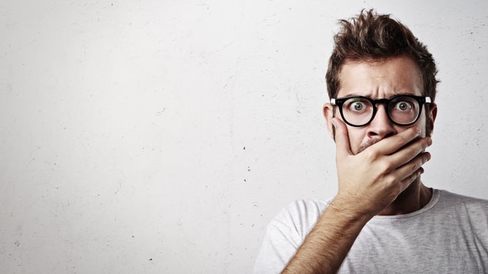 Person with hand over mouth in surprise.
