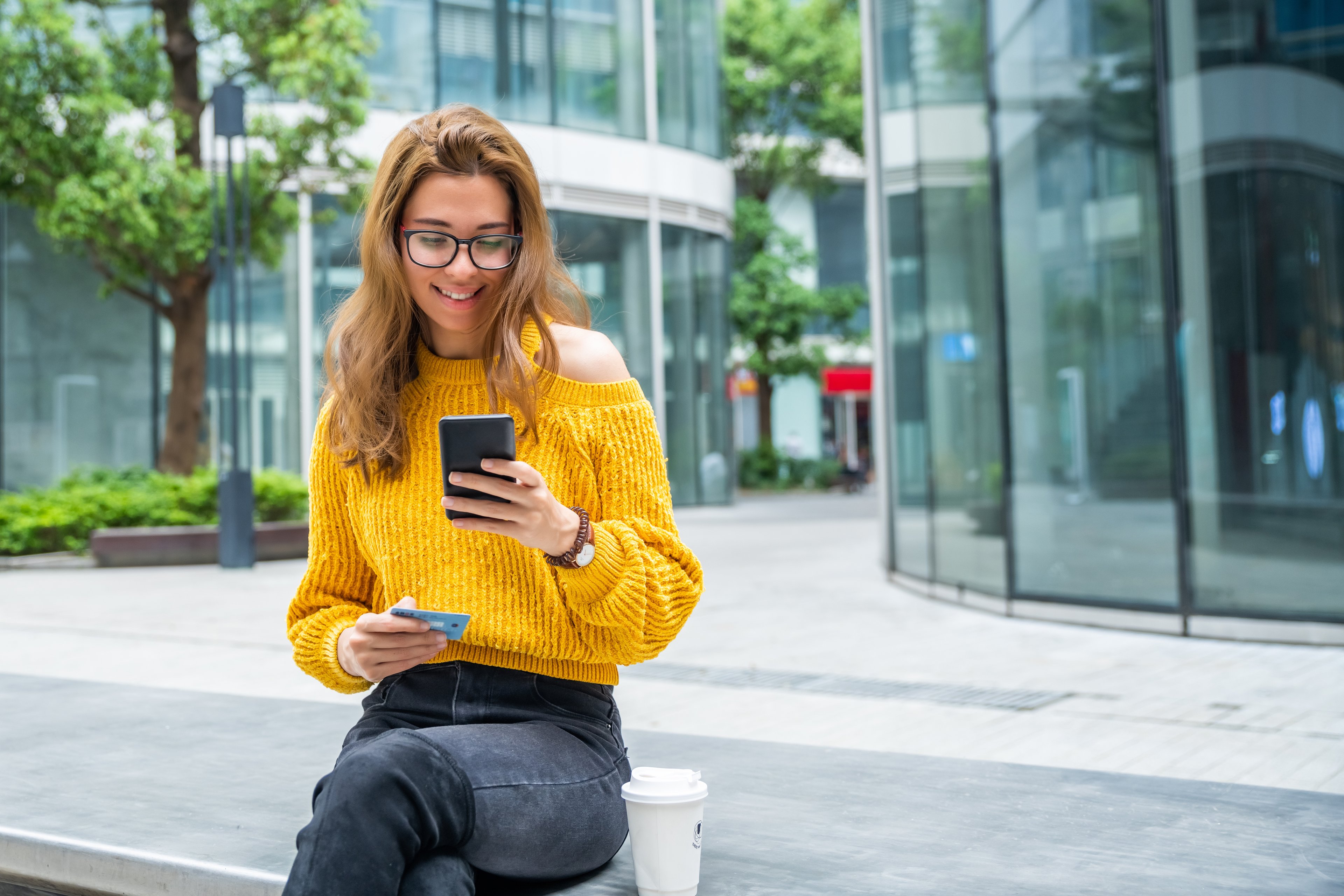 Person holding a credit card and a smartphone.