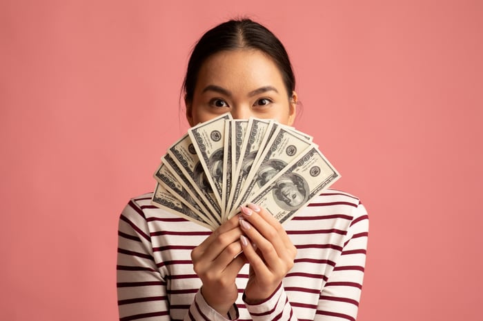 A person holding $100 bills.