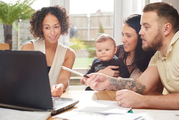 Advisor reviewing data on a laptop with a family.