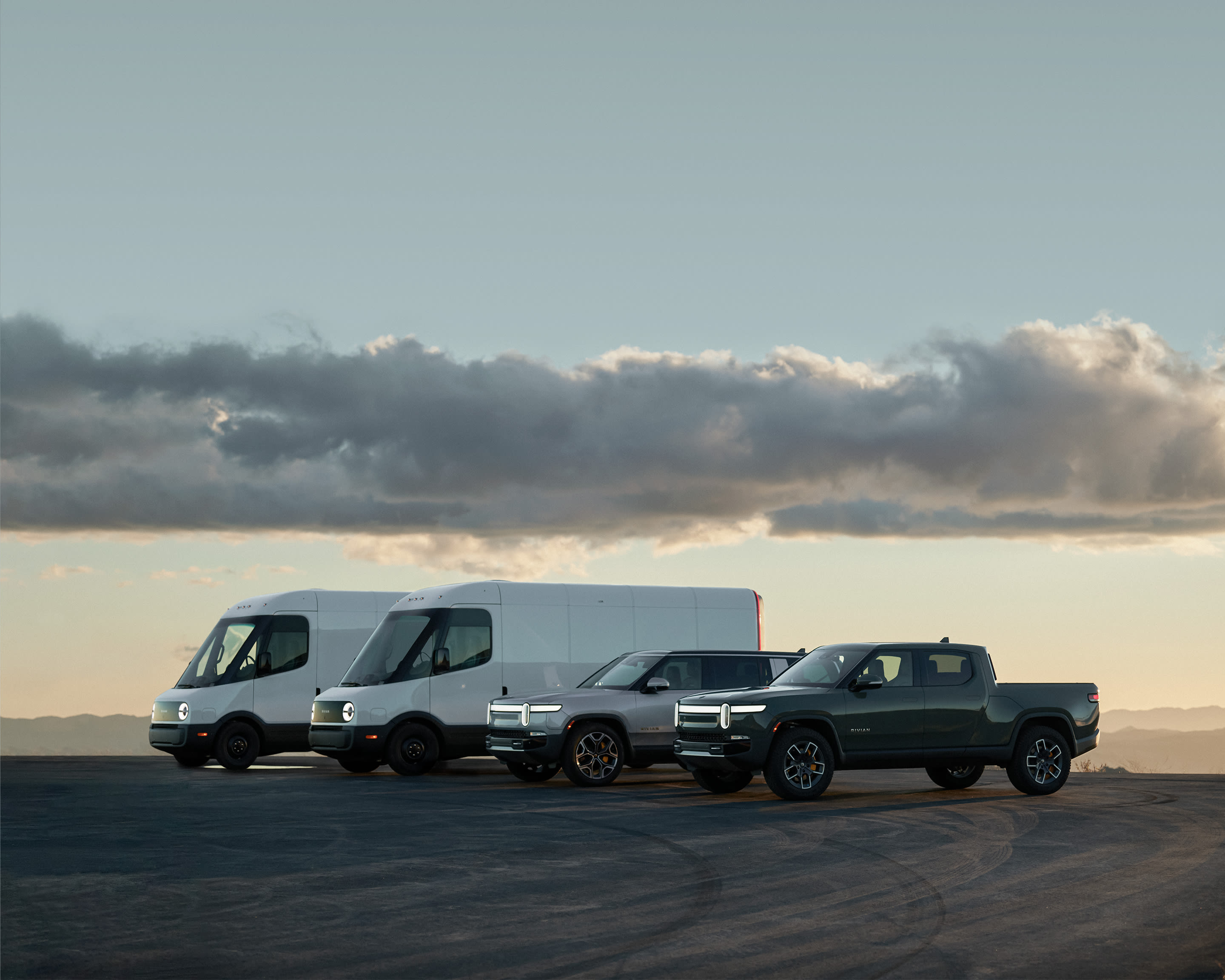 Image shows Rivian vehicles, including delivery vans, SUV, and truck.