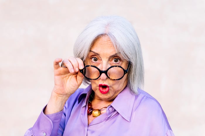 A person is taking off their glasses and looking surprised.