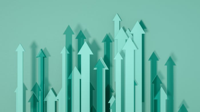A variety of different shades of green arrows pointing up sit against a green backdrop.