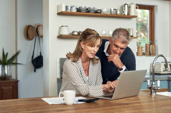 A couple looking at a computer screen.