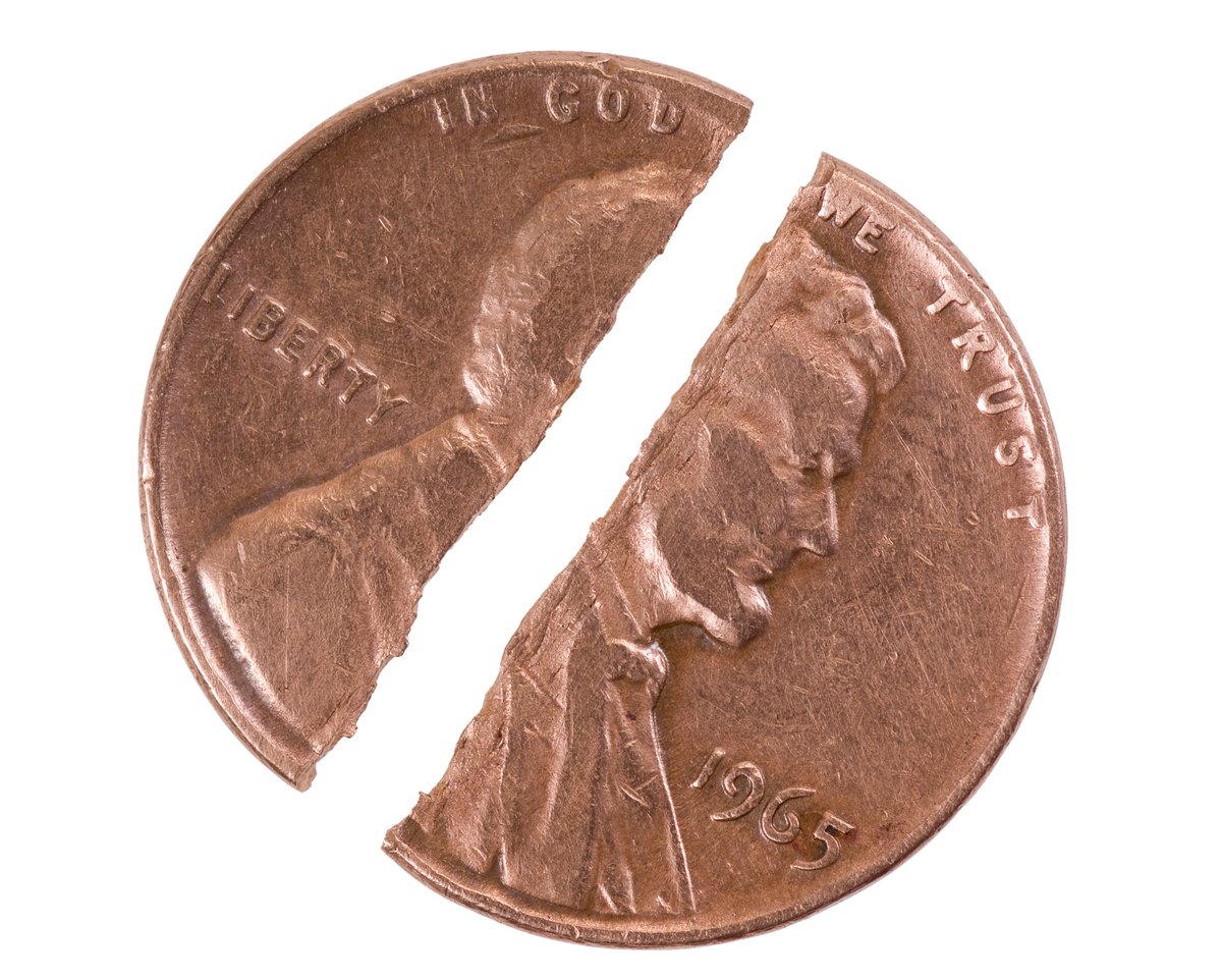A U.S. penny being cut in half. 