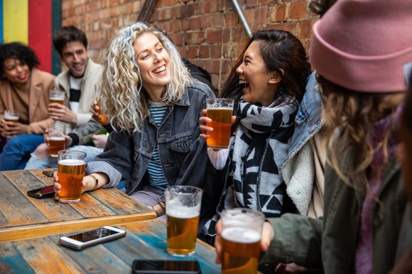 People smiling, enjoying beers. 