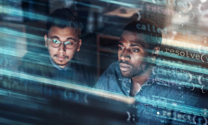 Two people looking at data on a screen.