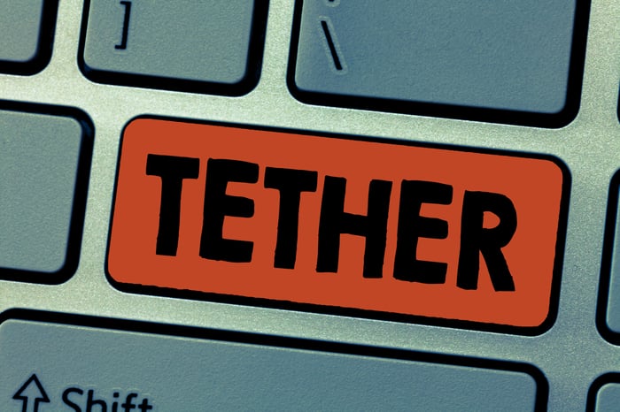 Orange Tether button a grey metallic keyboard.