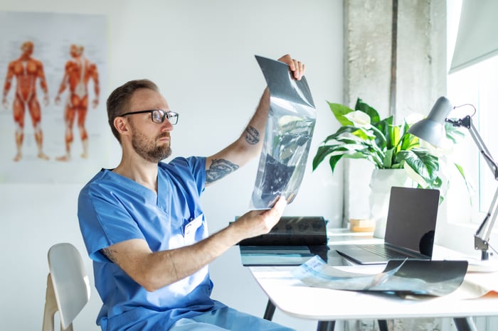 Healthcare professional inspecting charts.