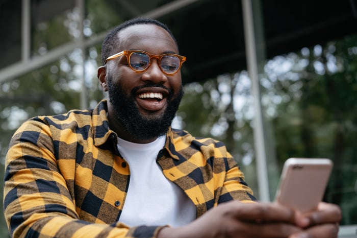 Someone is looking at their phone and smiling broadly. 