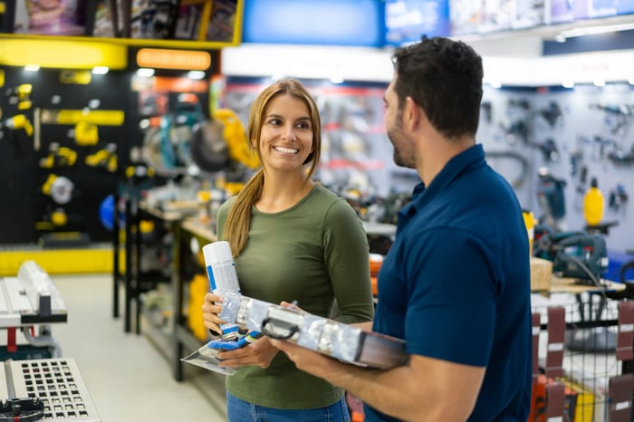 Two people in aisle of home improvement store.