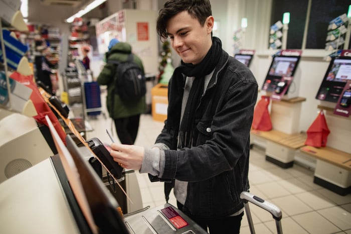 A person uses self-checkout at a store.