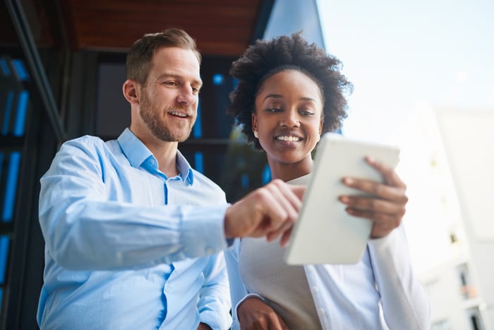 People study information on a tablet.