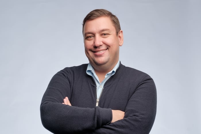Smiling person with arms crossed. 