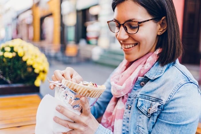A person eats out of a takeout container.