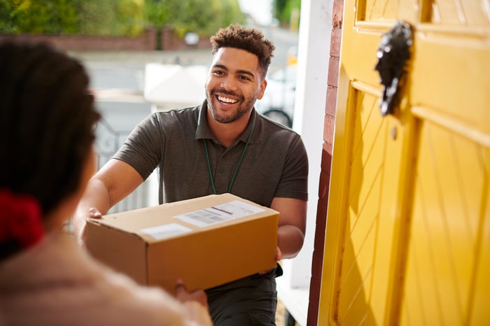 Delivery driver handing someone a package.
