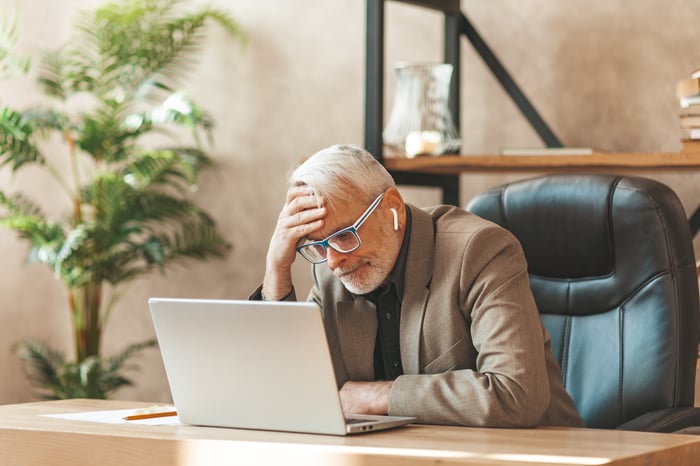 Person looking at their computer worried.
