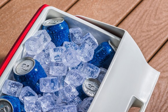 Blue cans of beer in a cooler full of ice.