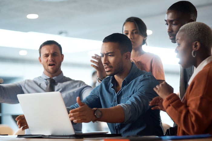 Frustrated people looking at a laptop.