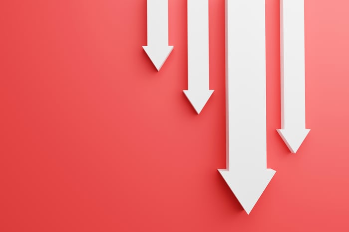 Four white arrows point down against a red backdrop.