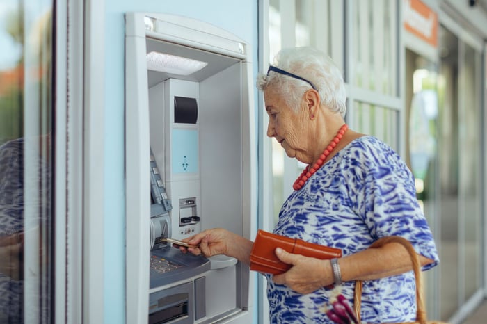 A person withdrawing money from an ATM.