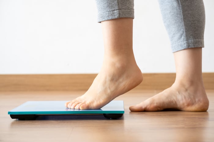 A person stepping on a scale.