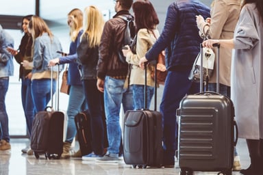Air travel passengers lined up at an airport.