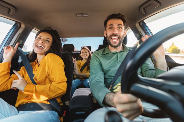 A family singing and dancing during a road trip.