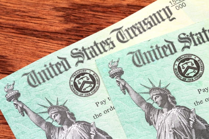 Two checks from the U.S. Treasury lying on a table. 