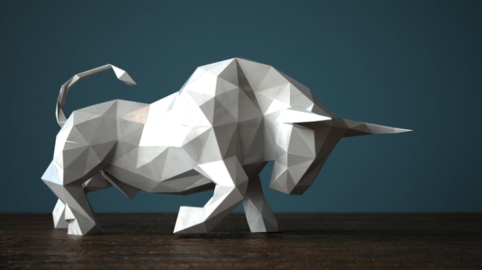 A white geometric bull with its head lowered and horns pointed forward.