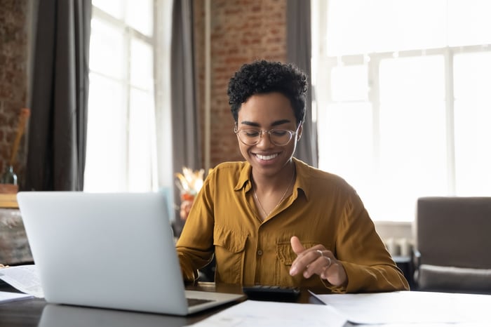 Smiling investor working on a laptop.