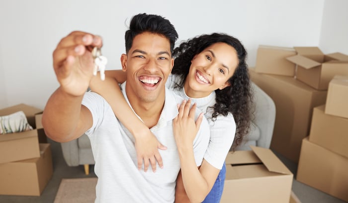 A couple with the keys to a house.