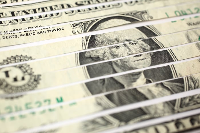A dollar bill in pieces after being shredded.