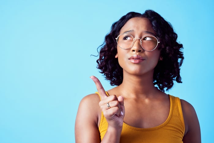 Person pointing and pondering while looking up.