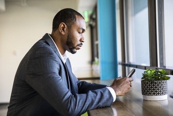 Investor checking stock prices on a smartphone.