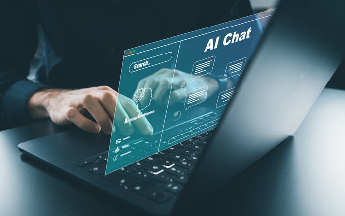 Person using laptop with virtual AI chat interface projected on screen.